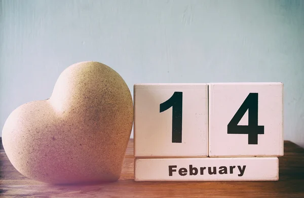 14 февраля деревянный винтажный календарь рядом с сердцем на деревянном столе. Vintage filtered — стоковое фото