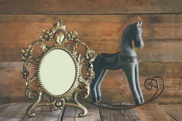 Antique quadro estilo vitoriano em branco e velho cavalo de balanço sobre mesa de madeira — Fotografia de Stock