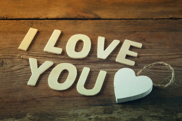 选择性焦点照片的字"我爱你"，用木质背景的块木字母。情人节庆祝概念。复古过滤和色调 — 图库照片
