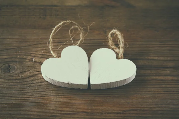 Selective focus photo of couple of wooden hearts on rustic table.  valentine's day celebration concept. — Stockfoto