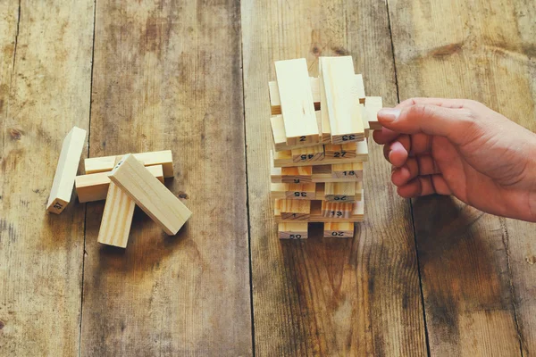 Vista superior de la mano masculina colocación de bloque de madera en una torre. concepto de planificación y estrategia — Foto de Stock