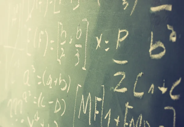 Vista laterale di formule matematiche e calcoli scritti sulla lavagna. focus selettivo . — Foto Stock