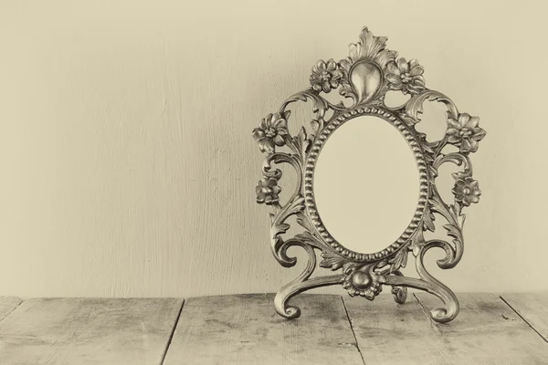 Antique blank victorian style frame on wooden table. black and white style photo. template, ready to put photography — 图库照片