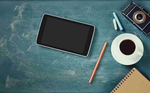 Top view image of tablet, cup of coffee and photo camera over blackboard background — Stok fotoğraf