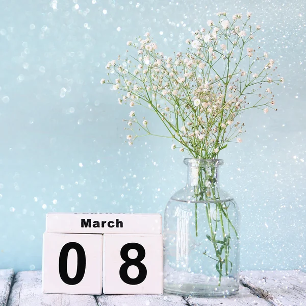Дерев'яний календар 8 березня, поруч з серцем і білими квітами на старому сільському столі. вибірковий фокус — стокове фото