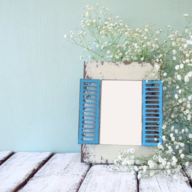 ahşap masa üzerinde beyaz çiçekler yanındaki eski ahşap çerçeve. Fotoğraf koymak hazır şablon