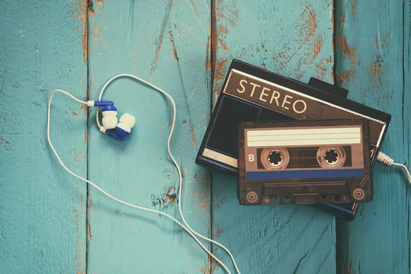 Cassette and old tape player over wooden background. retro filter — Stock Photo, Image