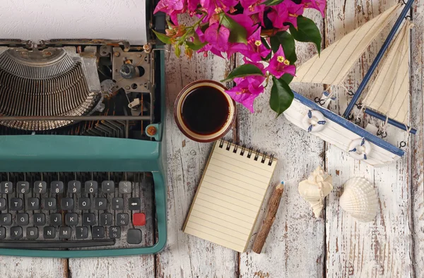 Imagen de máquina de escribir vintage, cuaderno en blanco, taza de café y velero viejo en mesa de madera —  Fotos de Stock