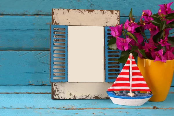 Vintage blank frame, sailboat next to beautiful purple mediterranean summer flowers. vintage filtered image. template, ready to put photography — Stock fotografie