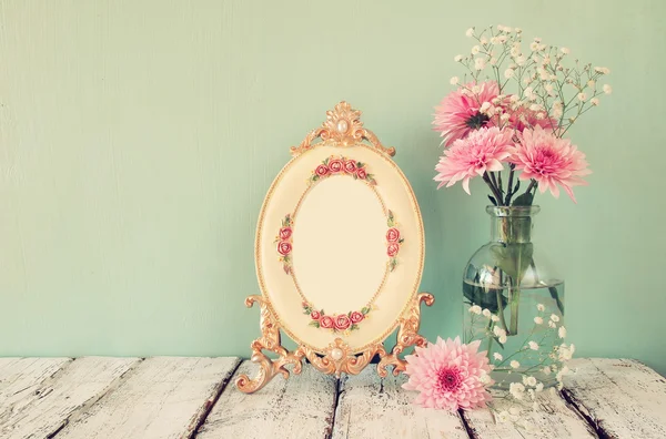 Imagem de flores rosa e branco e moldura antiga na mesa de madeira. vintage filtrado — Fotografia de Stock