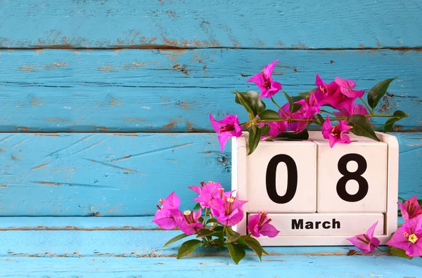 Fából készült március 8 naptári, lila virágok a régi kék rusztikus asztal mellett. szelektív összpontosít — Stock Fotó