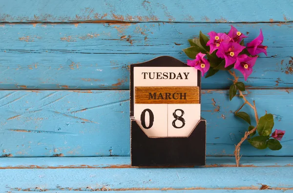 Trä den 8 mars kalender, bredvid lila blommor på gamla blå rustika bord. selektiv inriktning — Stockfoto