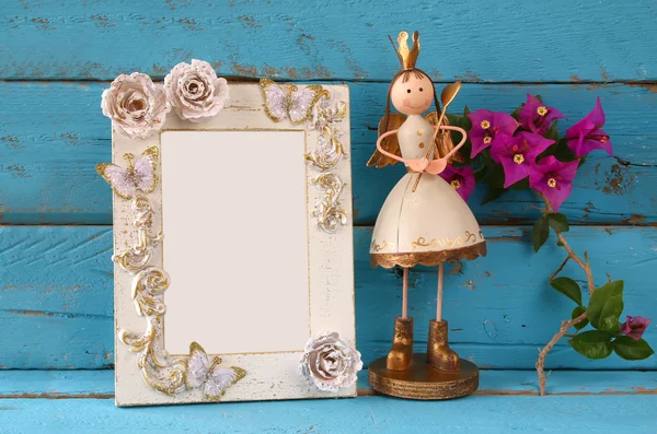 Imagem de moldura em branco vintage branco e princesa fada bonito na mesa de madeira — Fotografia de Stock