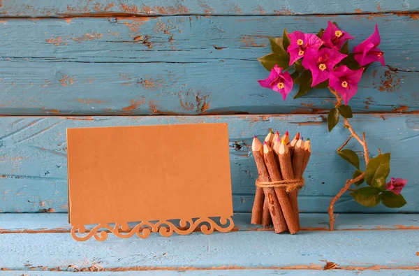Lila bougainvillea blommor, färgglada trä pennor bredvid vintage Töm kort över träbord — Stockfoto