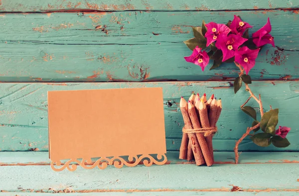 Lila bougainvillea blommor, färgglada trä pennor bredvid vintage Töm kort över träbord. Vintage filtreras — Stockfoto