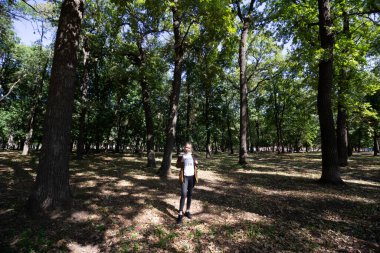 Güneşli havada parkta gözlüklü bir kız.