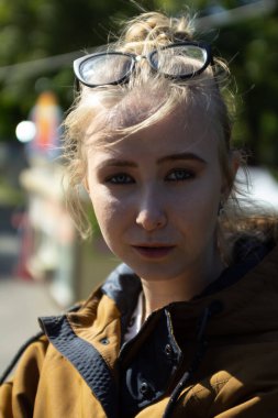 Güneşli havada parkta gözlüklü bir kız.