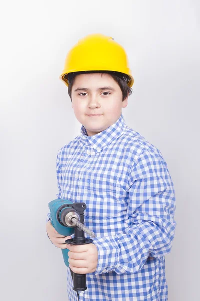 Builder boy holding a large drill — Stock Photo, Image
