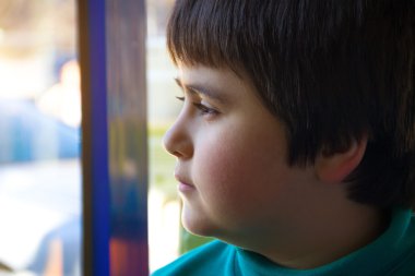 Pencereden dışarı bakarak bir esmer çocuk portresi