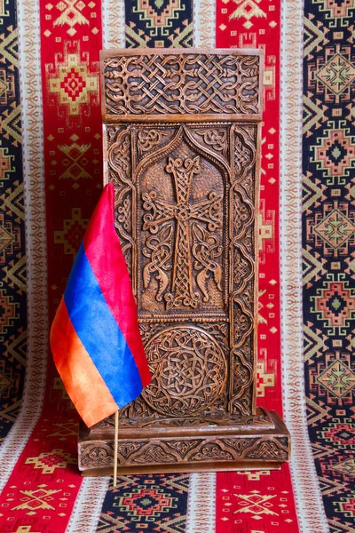 De oude Armeense Kruis-steen met een vlag op de achtergrond van het tapijt — Stockfoto