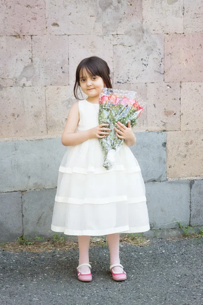 Lány a fehér ruha, állandó, és a kezében egy csokor, Rózsa — Stock Fotó