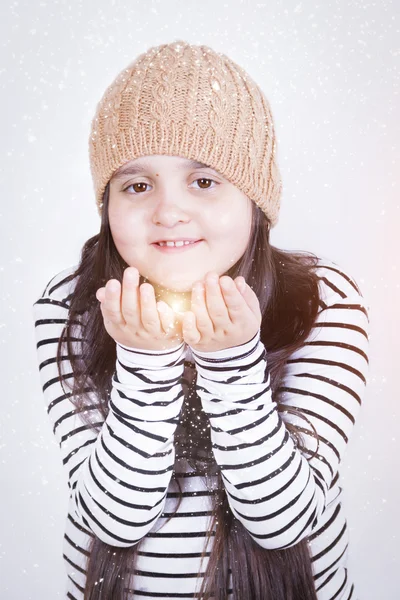 Chica con el pelo largo en beige sombrero de punto levantó las manos bajo la nieve —  Fotos de Stock