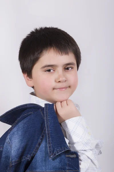 Portrait of a beautiful boy with a denim jacket on a gray background — Stock Photo, Image