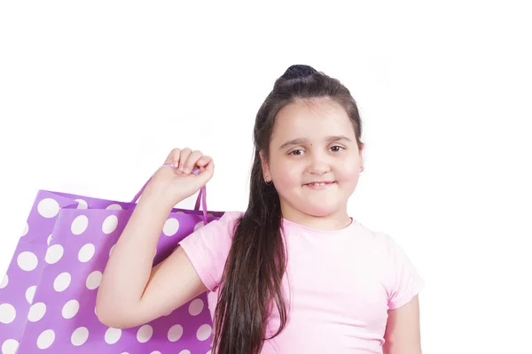Mädchen warf eine Papiertüte mit Tupfen über ihre Schulter und lächelte breit — Stockfoto