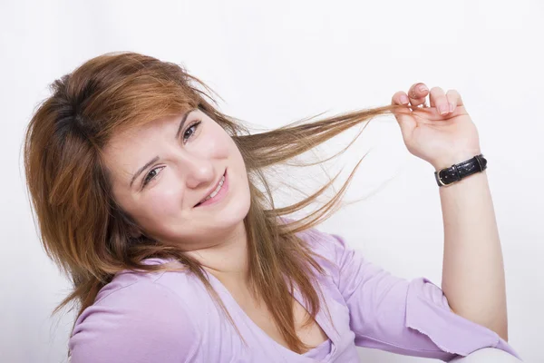 Red-haired girl playing with a lock of hair Stock Picture