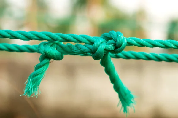 Rope tie knot Closeup. Rope with a two tied knot in the middle isolated from background. A symbol of trust, strength, safety support faith and togetherness concept. Illustrative conceptual photography