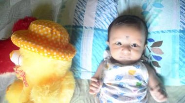 Teddy ile bebek. Evde yatağında oyuncak ayısı olan tatlı bir bebek çocuk. 3 aylık, tatlı, küçük bebek, yakın plan portresi. Hint etnik kökeni. Ön görünüm.