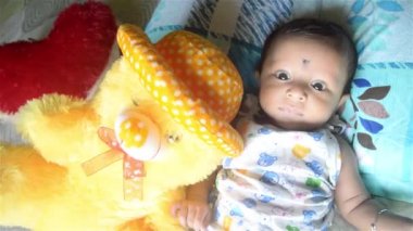 Teddy ile bebek. Evde yatağında oyuncak ayısı olan tatlı bir bebek çocuk. 3 aylık, tatlı, küçük bebek, yakın plan portresi. Hint etnik kökeni. Ön görünüm.
