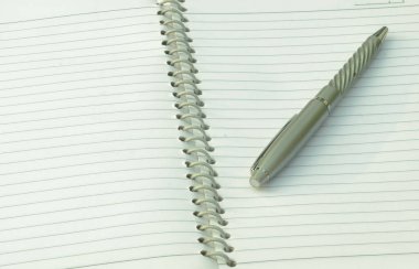 Spiral deftere yerleştirilmiş kalemi kapat. Tam kare çekim. Yüksek açı. İş eğitimi geçmişi.