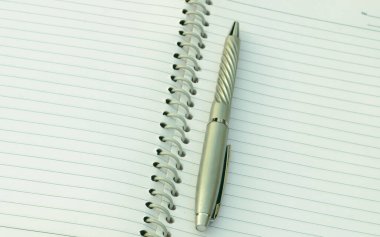 Spiral deftere yerleştirilmiş kalemi kapat. Tam kare çekim. Yüksek açı. İş eğitimi geçmişi.