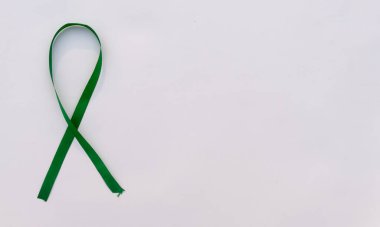 Beyaz arka planda Yeşil Farkındalık Kurdelesi. Masa üstü görünümü. Sağlık ve sağlık hizmetleri. Metin için alanı kopyala.