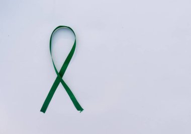 Beyaz arka planda yeşil kurdele. Masa üstü görünümü. metin için boşluk kopyala.