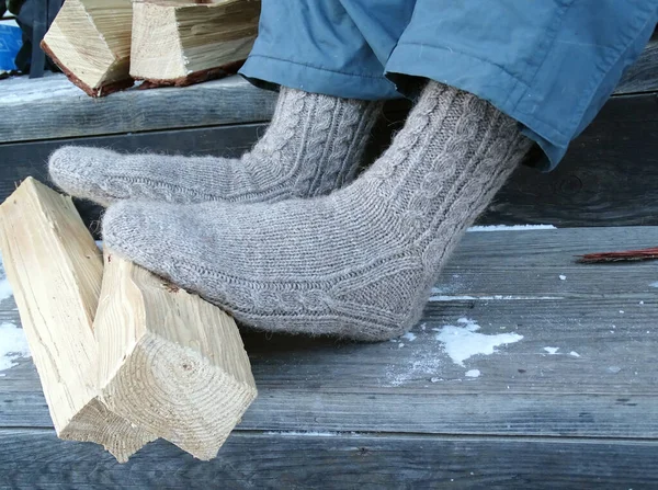 Pies de hombre en calcetines de lana en un porche de madera —  Fotos de Stock