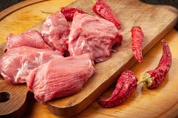 Tahtada et ve biber. Ahşap bir yüzeyde kurutulmuş biberli taze dana eti. Mutfak tahtasına sığır filetosu. Doğal yiyecek.. 