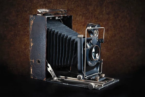 Old camera. Vintage camera open on a dark brown background. Antique items.