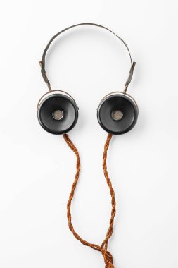 Eski kulaklıklar. Beyaz arka planda uzun kumaş telli klasik kulaklıklar. Eski radyo mühendisliği kavramı. Seçici yumuşak odak.