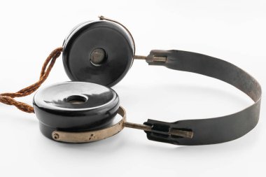 Eski kulaklıklar. Beyaz arka planda klasik plastik kulaklıkların yakın çekimi. Eski radyo mühendisliği kavramı. Seçici yumuşak odak.