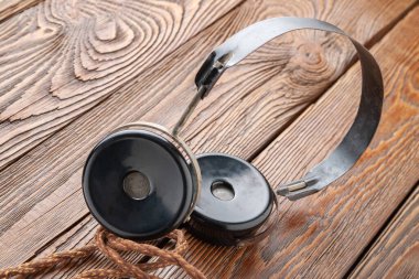 Eski kulaklıklar. Ahşap arka planda eski püskü kulaklıklar. Eski radyo mühendisliği kavramı. Seçici yumuşak odak.