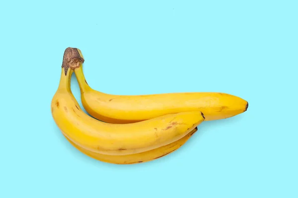 Banany Odizolowane Niebieskim Tle Trzy Dojrzałe Żółte Banany Banda Bananów — Zdjęcie stockowe