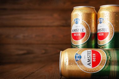 Su damlalı AMSTEL bira kutuları. Yoğunlaşmayla kaplı bira kutuları. Dünyaca ünlü Hollanda markası. Kopya alanı olan ahşap bir arkaplan. Seçici yumuşak odaklanma. Kiev. Ukrayna. Haziran-26.2021.