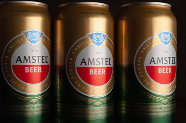 Bira kutuları. Kutularda AMSTEL birası. Kahverengi arka planda birkaç kutu var. Hollanda 'nın dünyaca ünlü markası. Seçici yumuşak odaklanma. Kiev. Ukrayna. Haziran-26.2021.