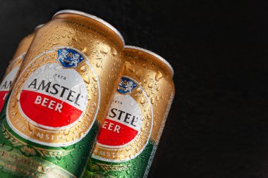 Su damlalı bira kutuları. Islak kutularda ıslak siyah arka planda fotokopi alanı olan AMSTEL birası. Hollanda 'dan dünyaca ünlü bir marka. Seçici yumuşak odaklanma. Kiev. Ukrayna. Haziran-26.2021
