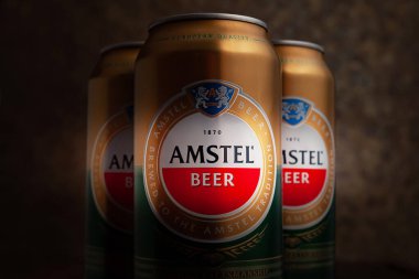 Bira kutuları. AMSTEL birası koyu kahverengi arka planda yakın plan kutularda. Hollanda 'nın dünyaca ünlü markası. Seçici yumuşak odaklanma. Kiev. Ukrayna. Haziran-26.2021.
