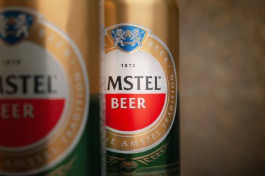 Bira kutuları. Kutularda AMSTEL birası. Kahverengi arka planda birkaç kutu var. Hollanda 'dan dünyaca ünlü bir marka. Seçici yumuşak odaklanma. Kiev. Ukrayna. Haziran-26.2021.