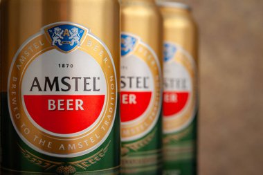 Bira kutuları. Soyut kahverengi arka planda yakın plan kutularda AMSTEL birası. Hollanda 'dan dünyaca ünlü bir marka. Seçici yumuşak odaklanma. Kiev. Ukrayna. Haziran-26.2021.