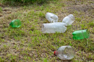 Plastik şişeler. Bahçedeki kuru çimlerin üzerinde kesilmiş bir yığın eski, kirli plastik şişe. Çevre kirliliği kavramı. Ekolojik bir sorun. Plastik atıkların geri dönüşümü. Seçici yumuşak odak.